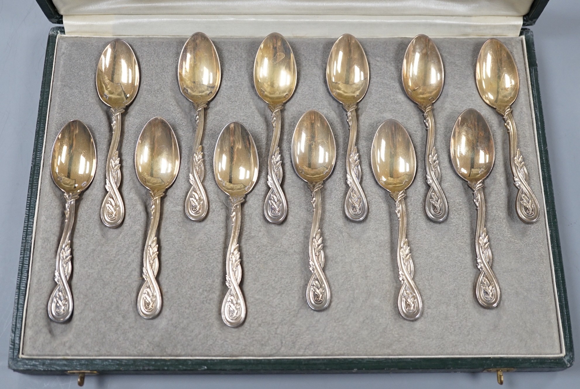 A cased set of twelve early 20th century French 950 standard white metal teaspoons, with foliate scroll terminals, by H. Freres & Co, 99mm.